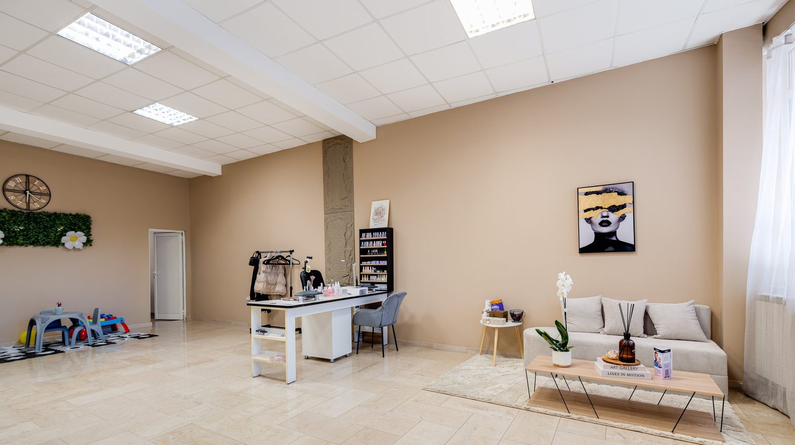 Зоната за отдих в PA||SE Beauty Studio – диван, растения и артистичният портрет на стената